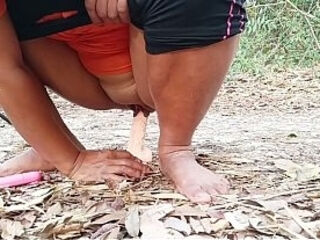 A pretty female student secretly spreads her legs in the woods and shoves a dildo into her anus.