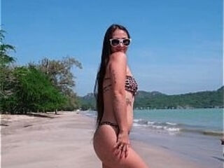 Sexy dancing in tight bikini on white sand beach